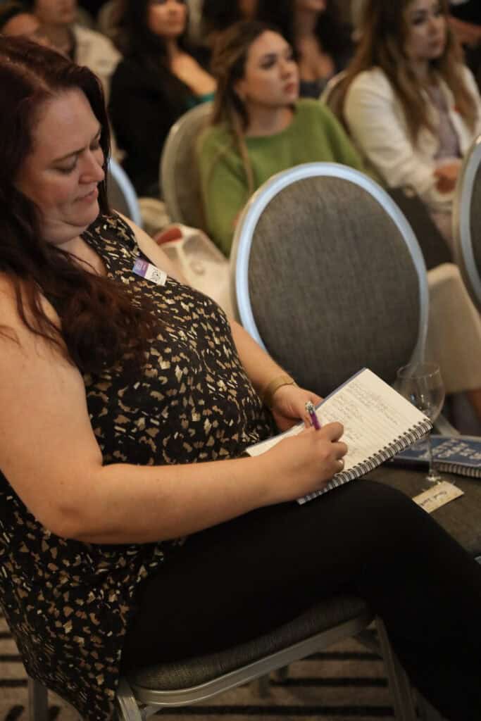 A woman taking notes on a notebook.