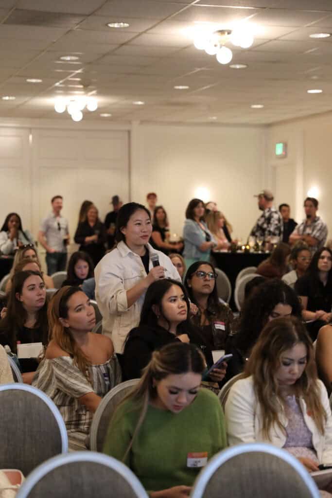 A woman in the audience standing up to ask a question during the panel discussion.